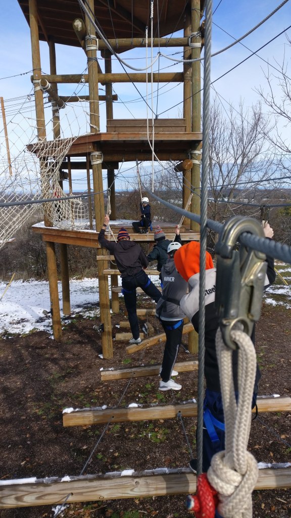 Team moving though high rope course